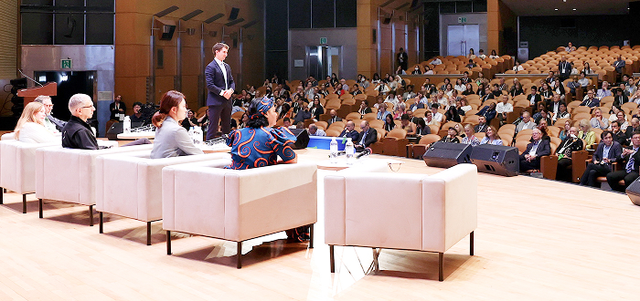 Panel of experts seated on stage at a formal healthcare event, engaging an audience in a discussion—highlighting professional collaboration and thought leadership.