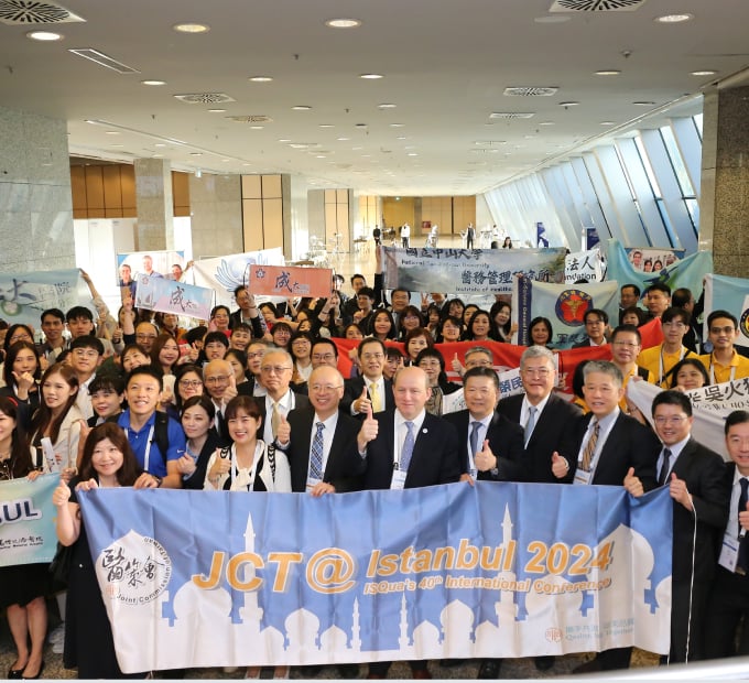 Group of smiling people holding banners at an international conference in Istanbul.