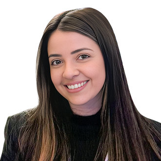 Paloma Alaminos De Lima with long, straight dark and light brown hair, wearing a black top and dark jacket, posing against a black background.