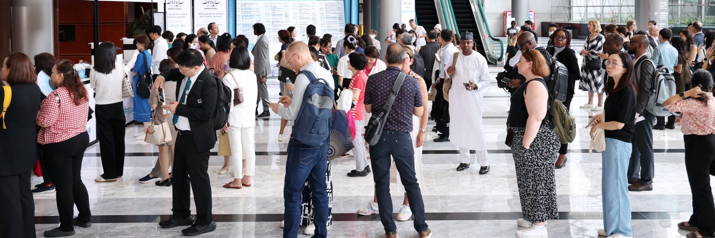 Crowd of diverse attendees registering at an international conference.