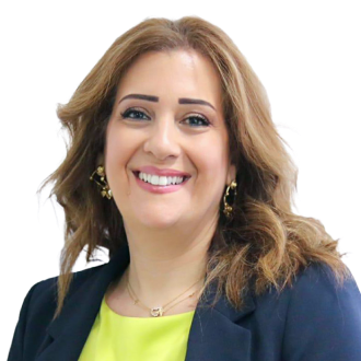 Salma Jaouni in a navy blazer and yellow top, smiling confidently against a black background.