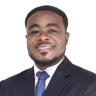 Sodzi Sodzi Tettey in a dark suit and polka dot tie, posing confidently against a black background.