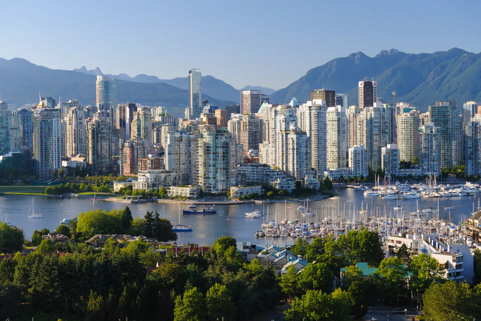 Vancouver skyline over False Creek marina with mountains in the background