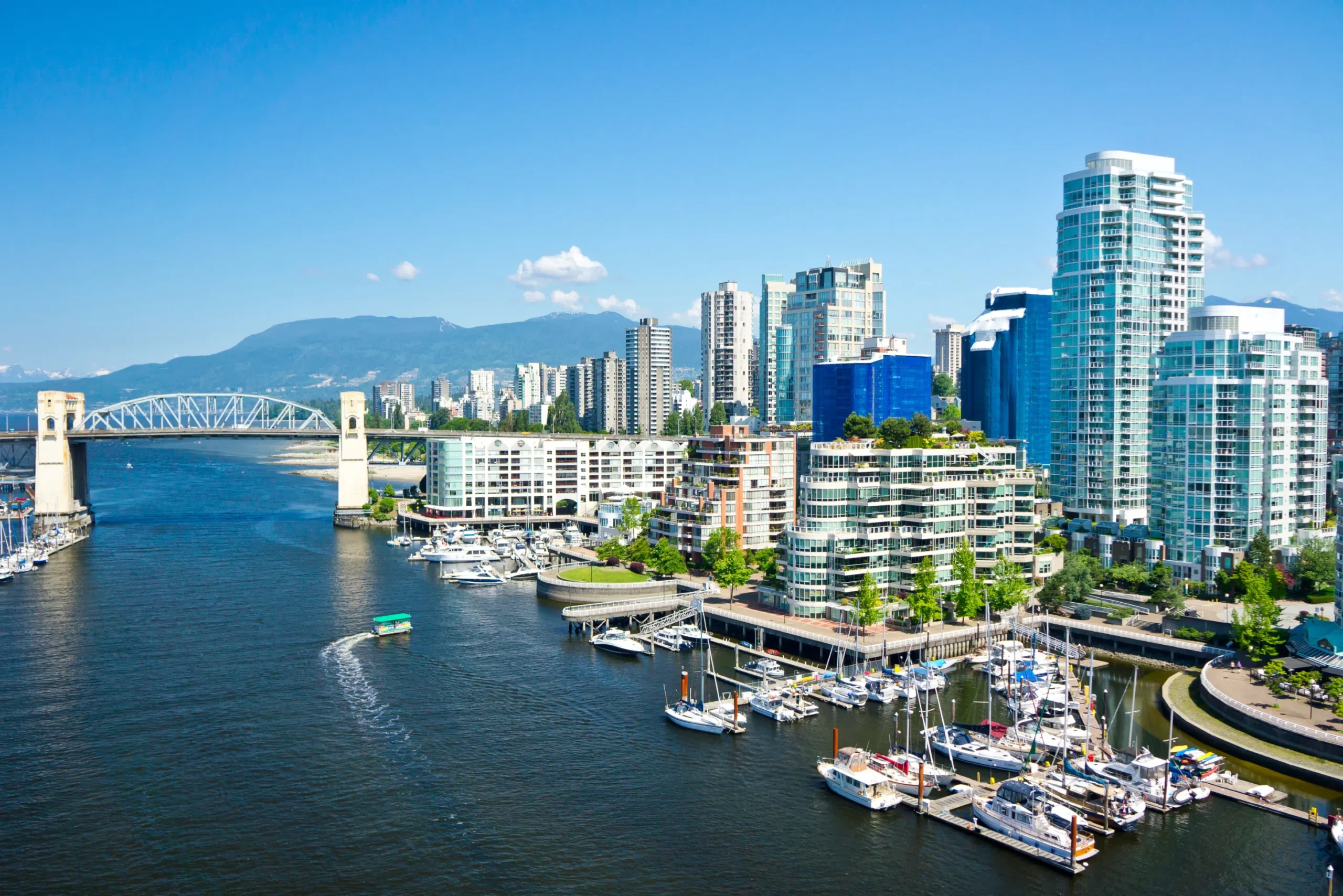 Vancouver skyline and False Creek marina with mountains in the background